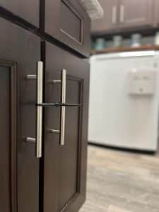 Childproofing cabinet doors with zip ties in laundry room. 